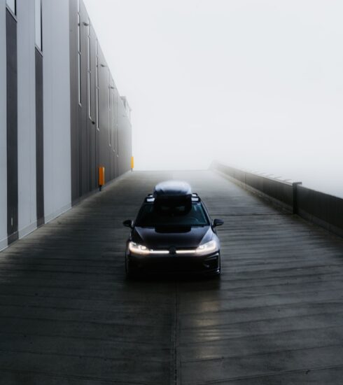 A car drives into the foggy distance.